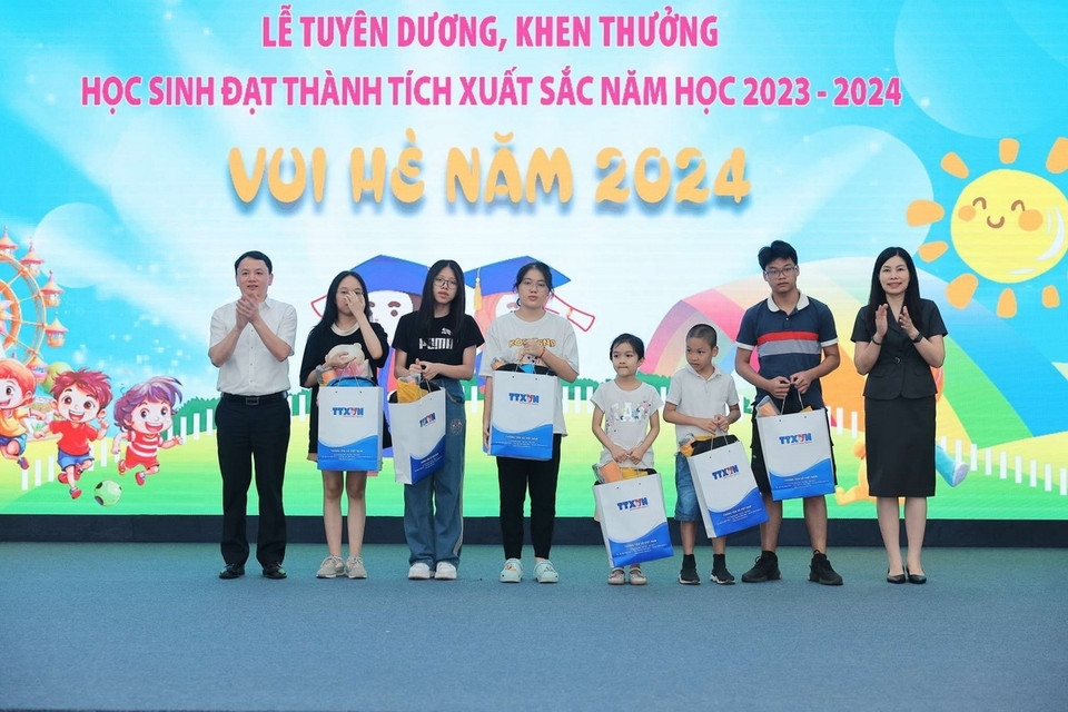 Phó Bí thư Thường trực Đảng ủy TTXVN Đỗ Thị Trang và Chủ tịch Công đoàn, Trưởng Ban Tổ chức-Cán bộ TTXVN Đỗ Mạnh Chiến trao thưởng tuyên dương học sinh đạt giải cấp tỉnh, thành phố. (Ảnh: Hoàng Hiếu/TTXVN)