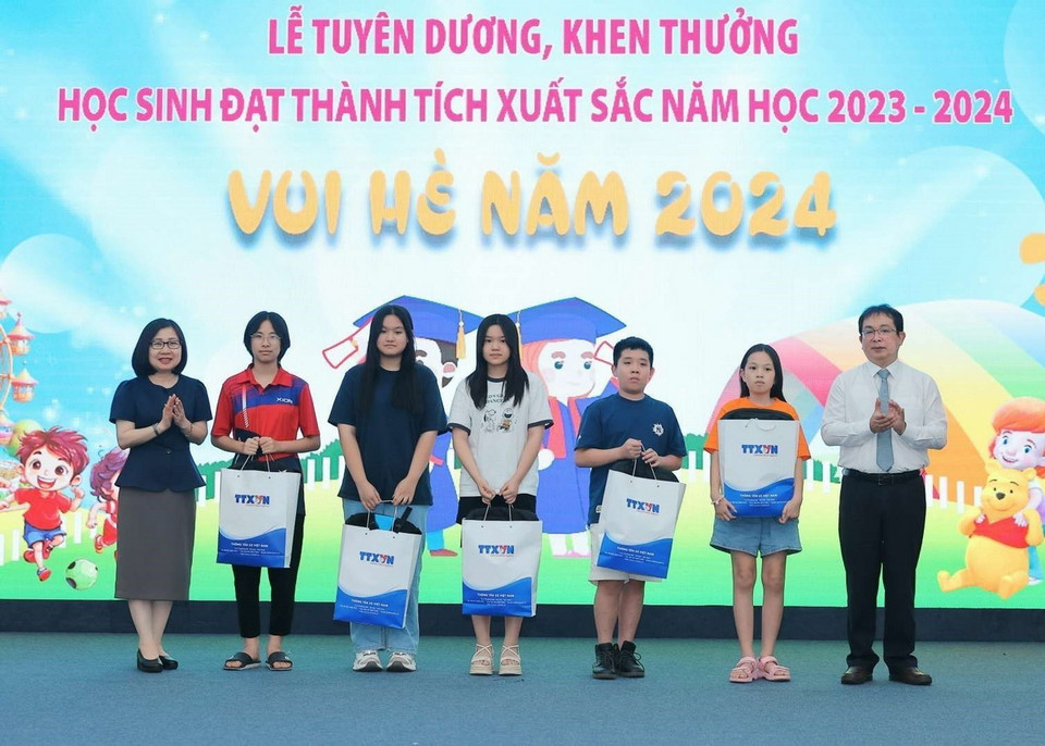 Các Phó tổng giám đốc TTXVN Nguyễn Tuấn Hùng và Đoàn Thị Tuyết Nhung trao phần thưởng tuyên dương học sinh đạt giải quốc gia. (Ảnh: Hoàng Hiếu/TTXVN)