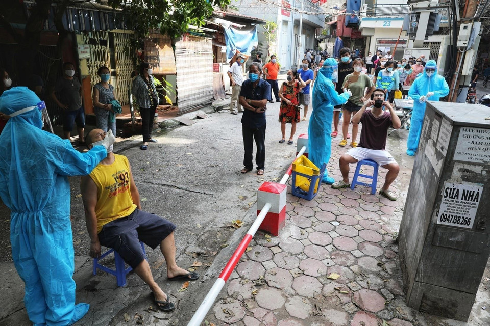Nhân viên y tế lấy mẫu xét nghiệm cho toàn bộ người dân tại ngõ Lương Sử C, phường Văn Chương, quận Đống Đa, ngày 12/8. (Ảnh: Thành Đạt/TTXVN)