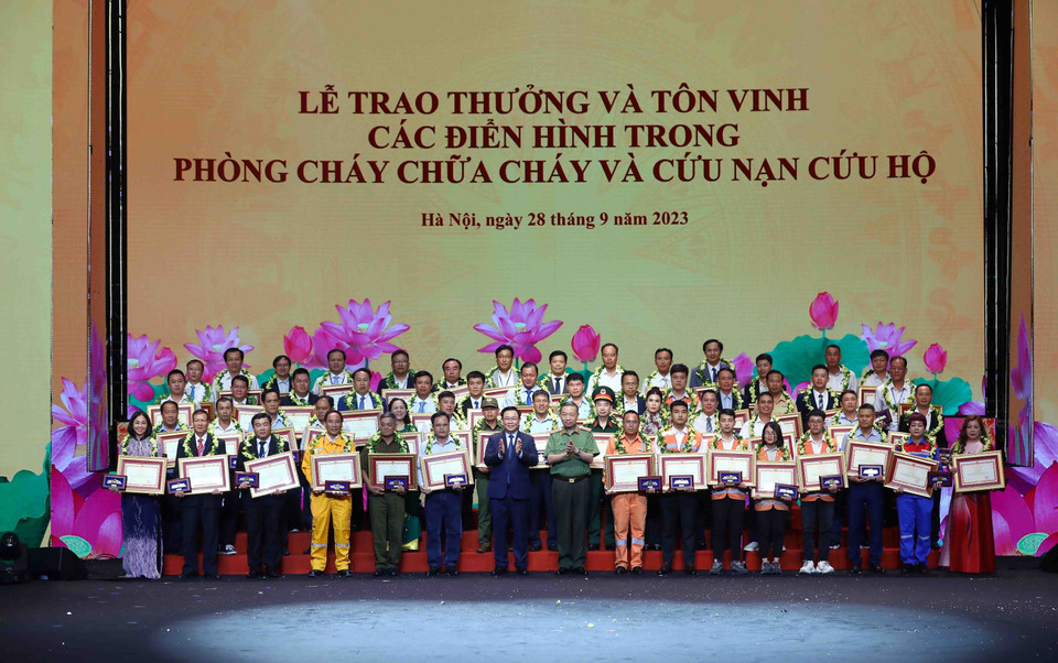 Chủ tịch Quốc hội Vương Đình Huệ và Đại tướng Tô Lâm, Bộ trưởng Bộ Công an tuyên dương các điển hình trong phong trào phòng cháy, chữa cháy và cứu nạn, cứu hộ. (Ảnh: Phạm Kiên/TTXVN)