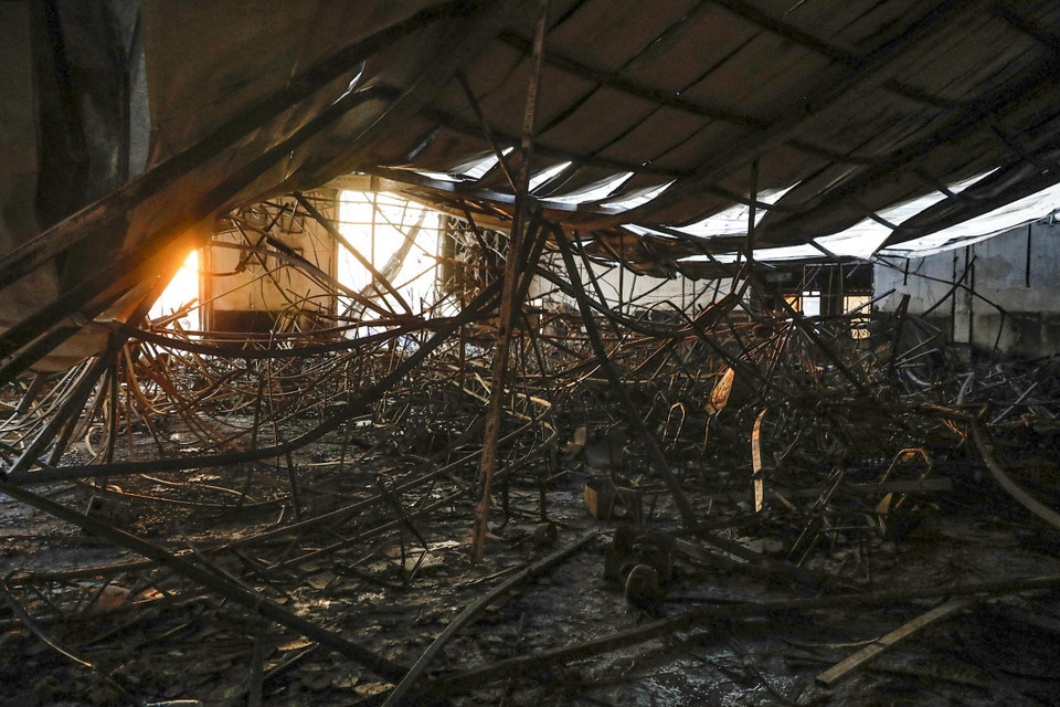 Điều tra ban đầu cho thấy tòa nhà được làm bằng vật liệu rất dễ cháy, khiến cơ sở này nhanh chóng đổ sập. (Ảnh: AFP/TTXVN)