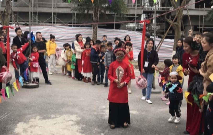 Du khách tham gia trò chơ bịt mắt đập niêu tại lễ hội hoa Xuân. (Ảnh: Tiến Vĩnh/TTXVN)