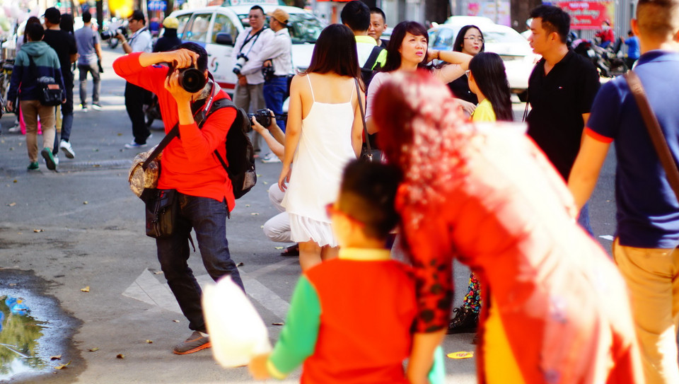 Khác so với mọi năm, năm nay người đến thưởng lãm và mua tranh, thư pháp thì ít, người đến chụp ảnh thì nhiều. (Ảnh: Lưu Đạt/Vietnam+)