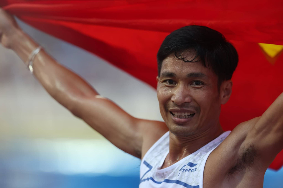 Vận động viên Nguyễn Văn Lai ăn mừng với lá Quốc kỳ sau khi giành Huy chương Vàng ở nội dung chạy 5.000m nam. (Ảnh: Ngô Trần Hải An/Vietnam+)