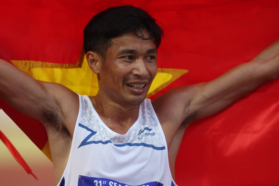 Vận động viên Nguyễn Văn Lai ăn mừng với lá Quốc kỳ sau khi giành Huy chương Vàng ở nội dung chạy 5.000m nam. (Ảnh: Ngô Trần Hải An/Vietnam+)