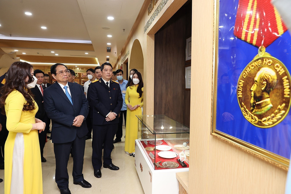 Thủ tướng Phạm Minh Chính tham quan Phòng truyền thống của Tổng Cục thuế. (Ảnh: Dương Giang/TTXVN)