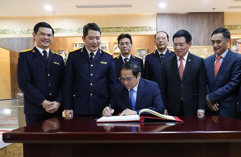 Thủ tướng Phạm Minh Chính viết lưu bút tại Phòng truyền thống của Tổng Cục thuế. (Ảnh: Dương Giang/TTXVN)