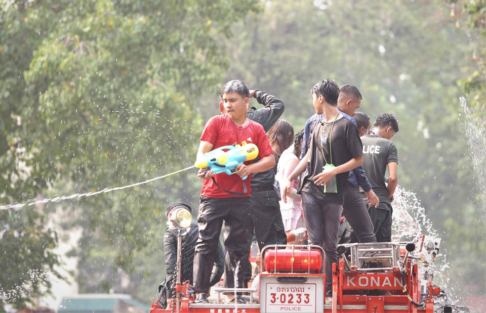 Các thành viên Ban tổ chức sự kiện Sangkran Wat Phnom 2023 ở thủ đô Phnom Penh cũng trở thành một phần của hoạt động té nước, bôi bột mỳ lên mặt… (Ảnh: Huỳnh Thảo/TTXVN)