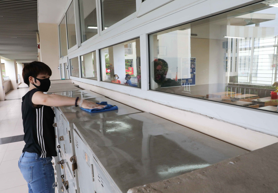 Phụ huynh cùng giáo viên Trường THCS Nghĩa Tân (quận Cầu Giấy) tiến hành vệ sinh, khử khuẩn toàn bộ trường học. (Ảnh: Thanh Tùng/TTXVN)