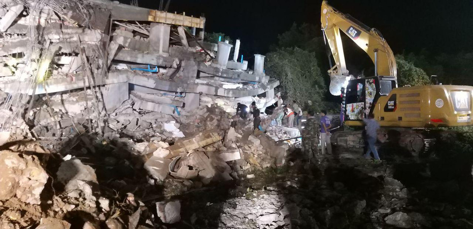 Lực lượng cứu hộ nỗ lực tìm kiếm những người bị vùi lấp. (Ảnh: Fresh News/Vietnam+)