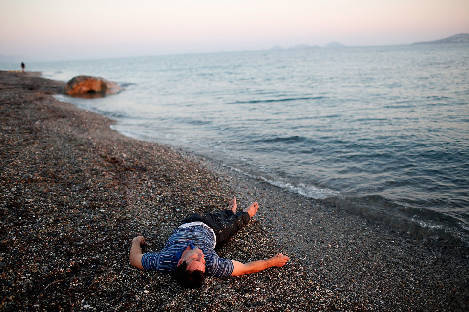 Người nhập cư Syria nằm nghỉ trên bờ biển đảo Kos sau khi bơi vào bờ. (Ảnh: Getty Images)