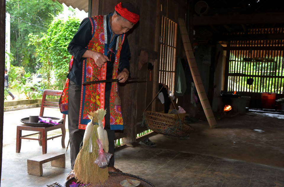 Thầy cúng cân lúa, ngô trước khi phát làm giống cho gia chủ. (Ảnh: Thế Duyệt​/TTXVN)