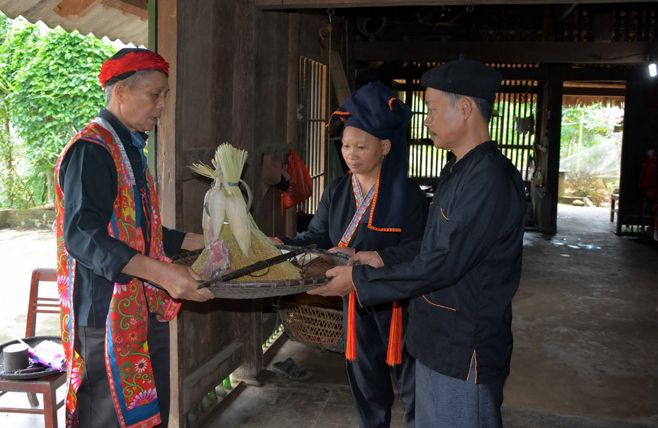 Thầy cúng phát lúa, ngô sau khi đã làm lễ để gia đình làm giống. (Ảnh: Thế Duyệt/TTXVN)
