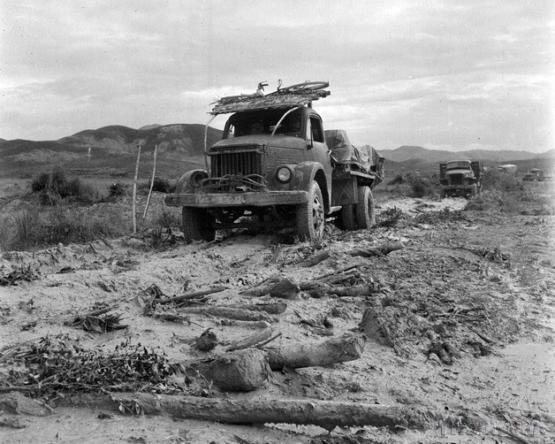 Bên những hố bom nham nhở do bom Mỹ gây ra trên đất lửa Hà Tĩnh, đoàn xe vẫn dũng cảm vượt mọi khó khăn đưa hàng tới địch an toàn (1968). (Ảnh: Văn Sắc/TTXVN)