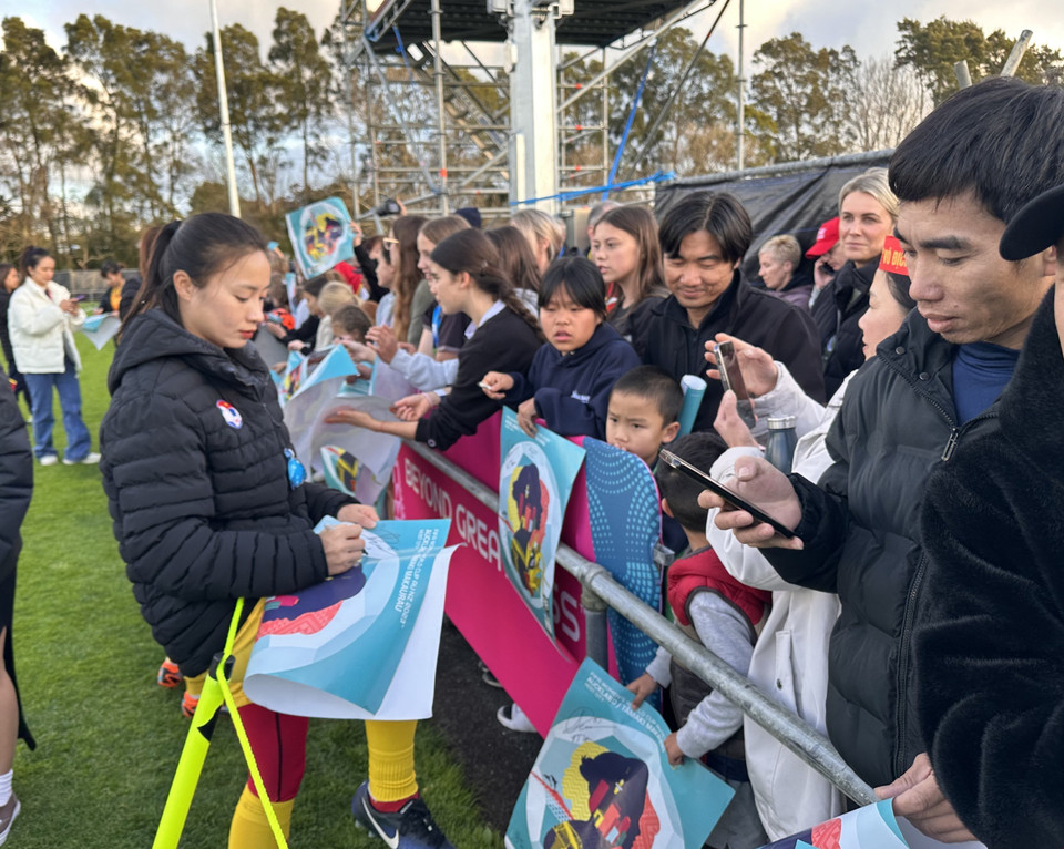 Cầu thủ Hoàng Thị Loan ký tên tặng người hâm mộ. (Ảnh: Trương Anh Ngọc/TTXVN)