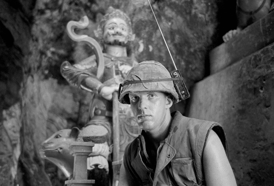 Binh sỹ Mỹ David L. Cruz nghe tin tức về tàu Apollo bằng radio gắn trên mũ khi đứng gác tại Núi Đá, Đà Nẵng ngày 17/7/1969. (Ảnh: AP)