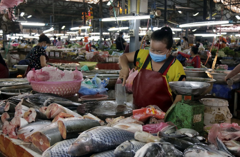 Dù không có người giám sát, những người bán hàng vẫn tuân thủ quy định đeo khẩu trang. (Ảnh: Phạm Kiên/Vietnam+)