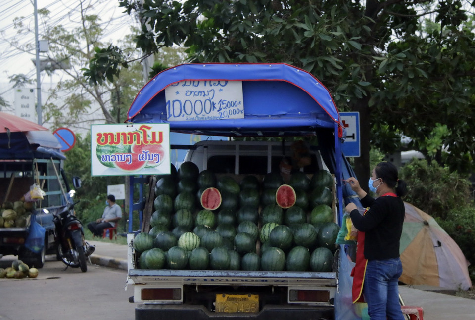 Những người bán hàng rong ngoài đường cũng đều đeo khẩu trang để bảo vệ mình và cộng đồng. (Ảnh: Phạm Kiên/Vietnam+)