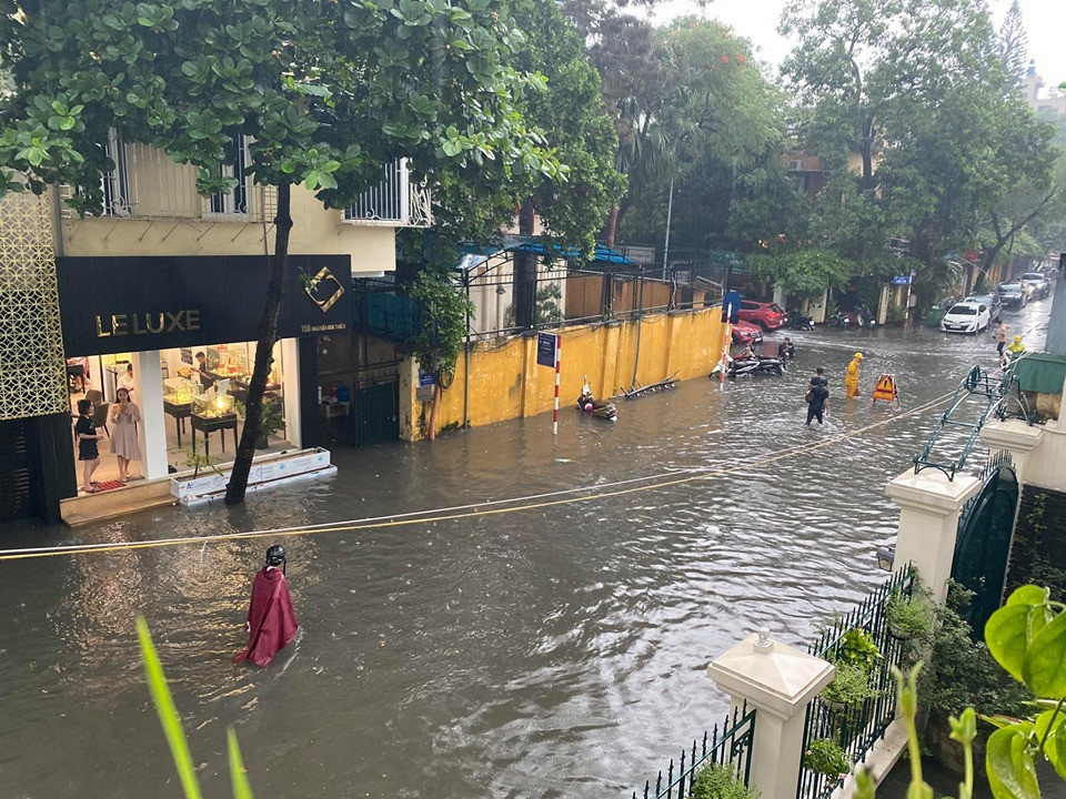Người dân phải lội bì bõm trong dòng nước bẩn. (Ảnh: Vietnam+)
