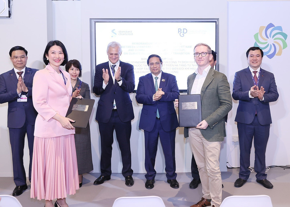 Thủ tướng Phạm Minh Chính và ông Bill Winters, Tổng Giám đốc toàn cầu Ngân hàng Standard Chartered chứng kiến trao văn kiện hợp tác.