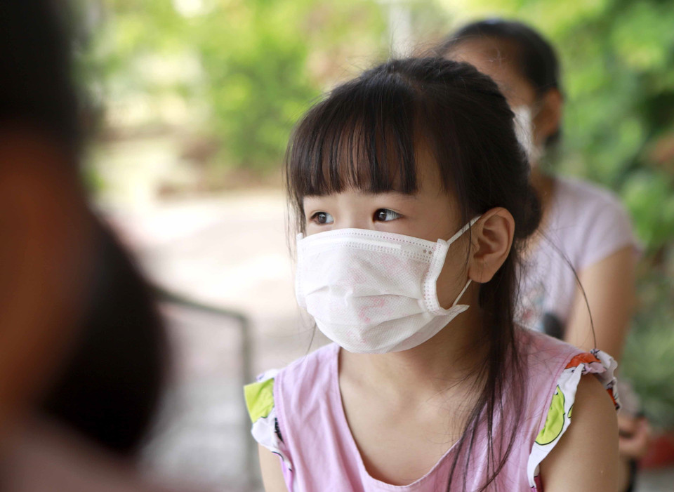 Một học sinh ngồi xếp hàng đợi xét nghiệm COVID -19. (Ảnh: Hoàng Hùng/TTXVN)