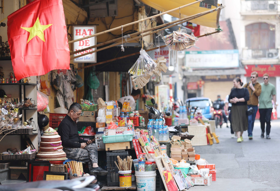 Một tiểu thương phố Tô Tịch chiều 30 Tết. (Ảnh: Hoàng Hiếu/TTXVN)