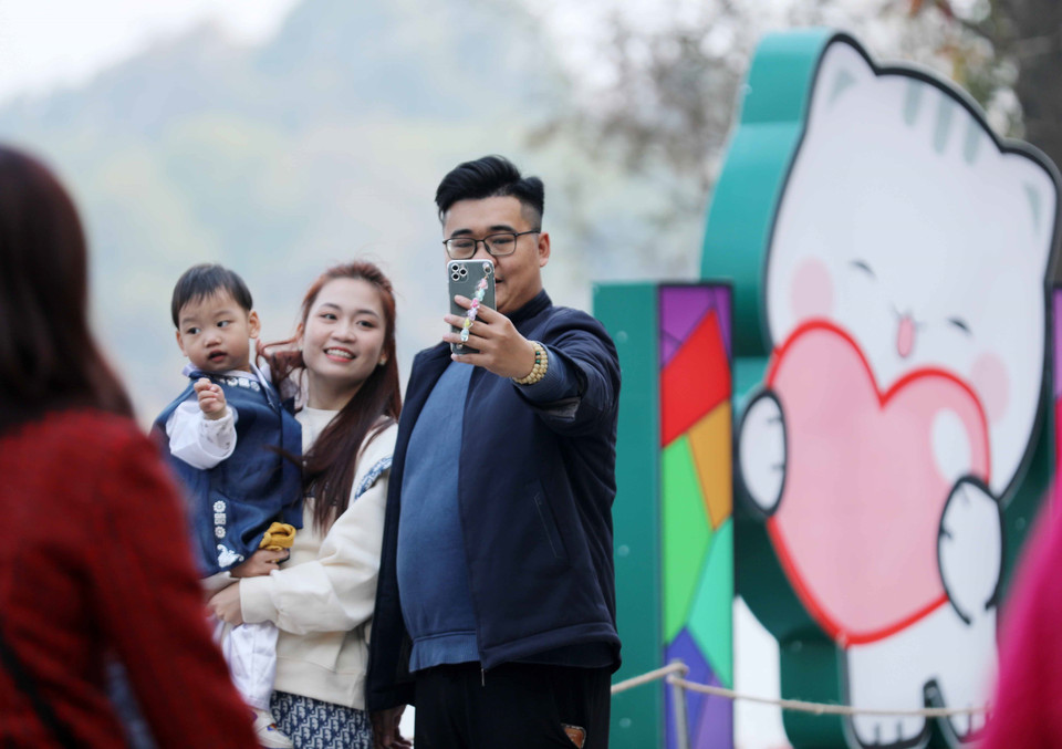 Một gia đình dạo chơi khu vực Hồ Gươm chiều cuối năm. (Ảnh: Hoàng Hiếu/TTXVN)