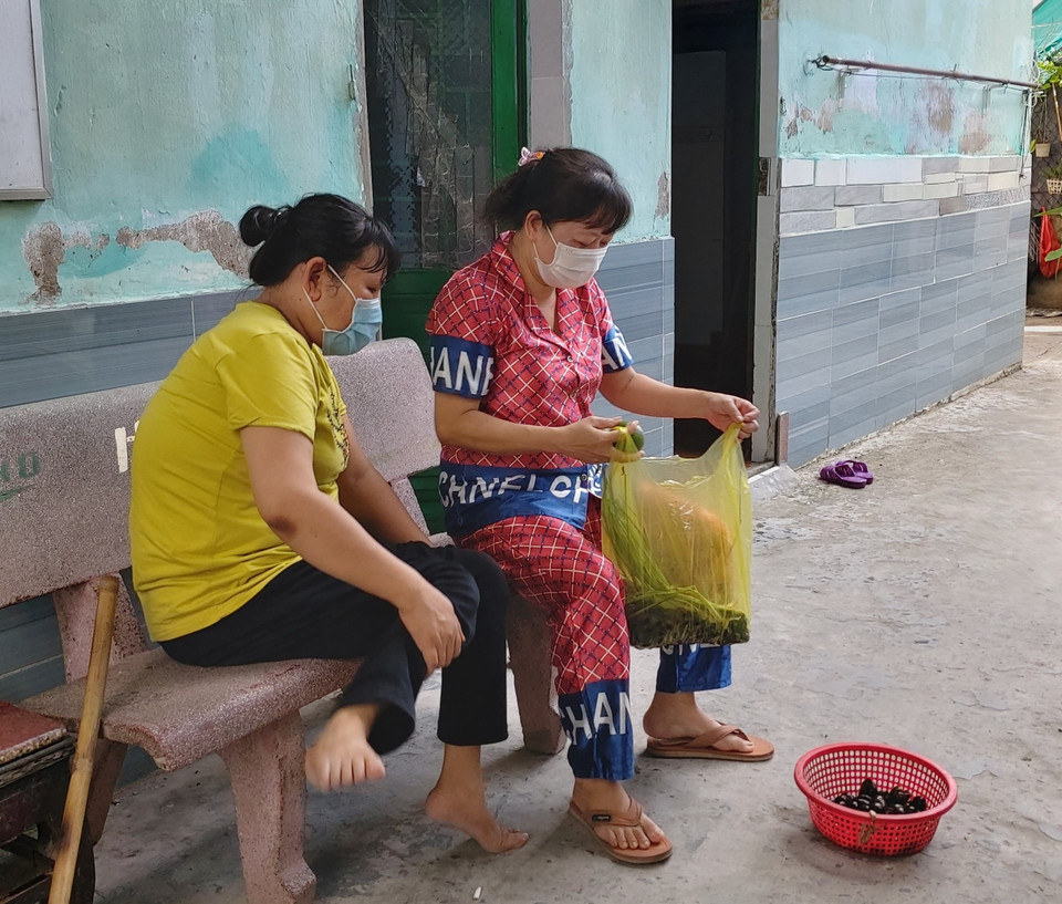 Chị em công nhân ở trọ phường Trà Nóc, quận Bình Thủy, chia sẻ nhau con ốc được nhóm từ thiện hỗ trợ. (Ảnh: Thu Hiền/TTXVN)