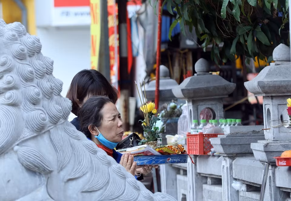 Vẫn còn nhiều người đến hành lễ bên ngoài tại khu di tích Đình - Chùa Bia Bà La Khê, quận Hà Đông dù đã có thông báo đóng cửa. (Ảnh: Phan Tuấn Anh/TTXVN)