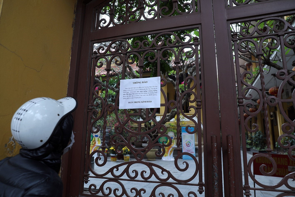 Người dân đọc thông báo đóng cửa tại Chùa Quán Sứ, trụ sở của Giáo hội Phật giáo Việt Nam. (Ảnh: Phan Tuấn Anh/TTXVN)