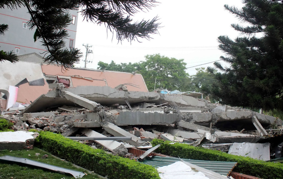 Căn nhà 5 tầng bị sập, đổ vùi lấp cả đường đi và một phần khu công viên nằm bên cạnh. (Ảnh: Quốc Đạt/TTXVN)