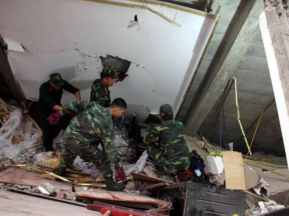 Lực lượng cứu hộ đang tìm kiếm các nạn nhân trong đống đổ nát. (Ảnh: Quốc Đạt/TTXVN)