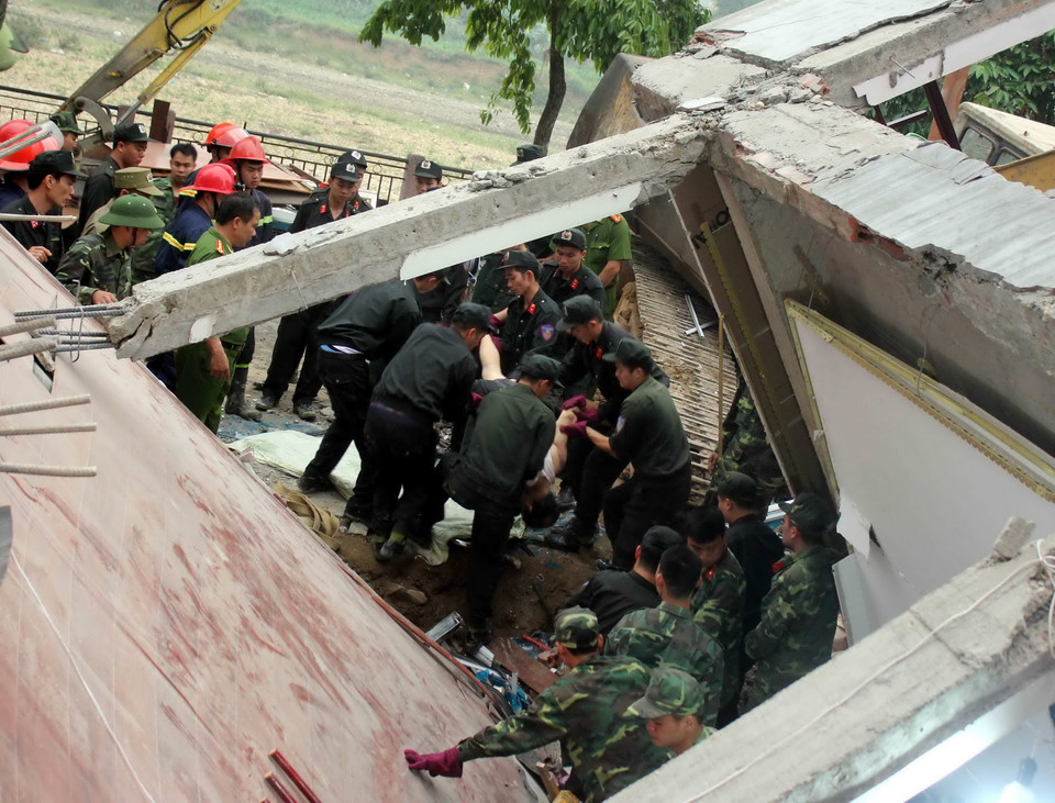 Lực lượng cứu hộ tìm kiếm được một nạn nhân trong đống đổ nát. (Ảnh: Quốc Đạt/TTXVN)