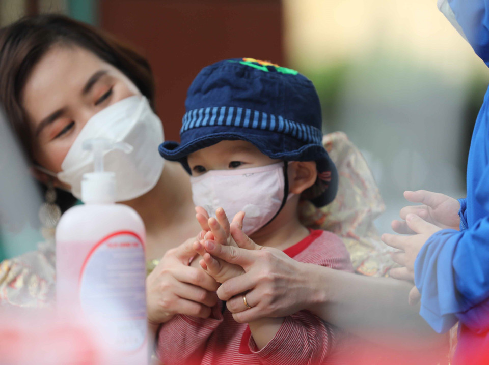 Bé được cô hướng dẫn sát khuẩn tay. (Ảnh: Thanh Tùng/TTXVN)