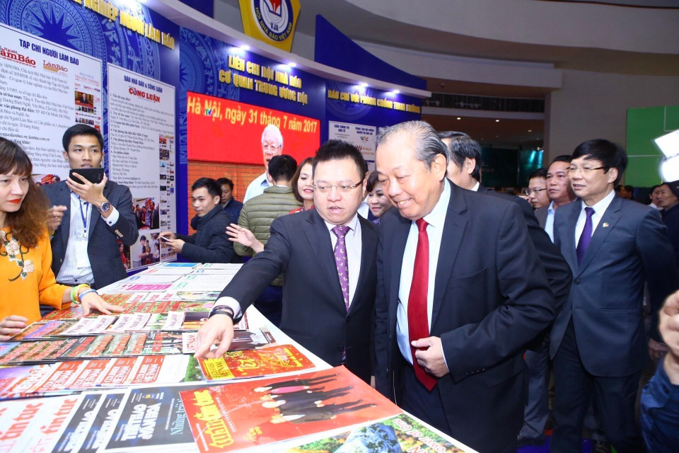 Phó Tổng Giám đốc TTXVN Lê Quốc Minh giới thiệu với Phó Thủ tướng Thường trực Trương Hòa Bình về các ấn phẩm của Thông tấn xã Việt Nam tham gia Hội báo toàn quốc năm 2019. (Ảnh: Minh Quyết - TTXVN)