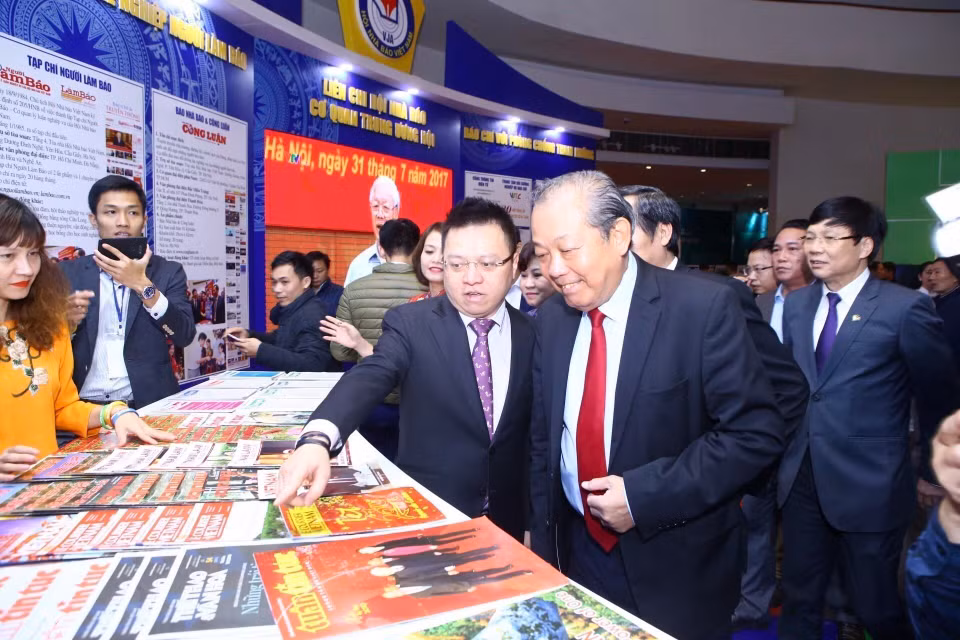 Phó Tổng Giám đốc TTXVN Lê Quốc Minh giới thiệu với Phó Thủ tướng Thường trực Trương Hòa Bình về các ấn phẩm của Thông tấn xã Việt Nam tham gia Hội báo toàn quốc năm 2019. (Ảnh: Minh Quyết - TTXVN)