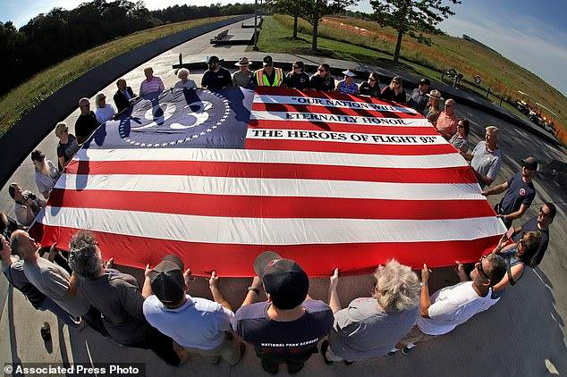 Người dân cầm lá cờ tưởng nhớ nạn nhân trên chuyến bay số 93 của United Airlines, một phần trong loạt vụ khủng bố ngày 11/9. (Ảnh: AP)