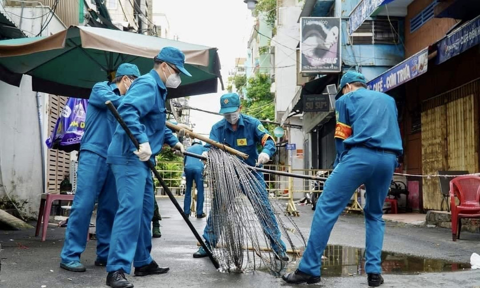 Các lực lượng thu dọn rào chắn trên đường Nguyễn Thiện Thuật (Quận 3, Thành phố Hồ Chí Minh). (Ảnh: Hồng Giang/TTXVN)