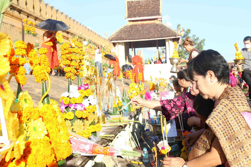 Một phụ nữ đang thắp hương cầu mong sự an lành cho gia đình và mọi người. (Ảnh: Phạm Kiên/Vietnam+)