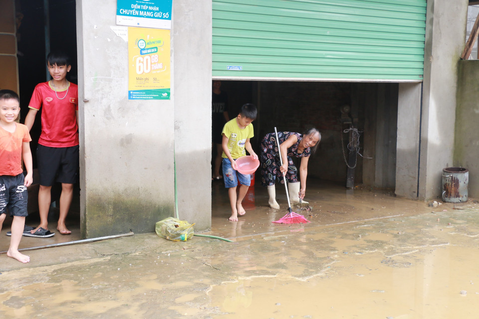 Người dân xóm Đông Xuân, xã Trung Phúc Cường, huyện Nam Đàn dọn dẹp khi nước đã rút dần.(Ảnh: Bích Huệ/TTXVN)