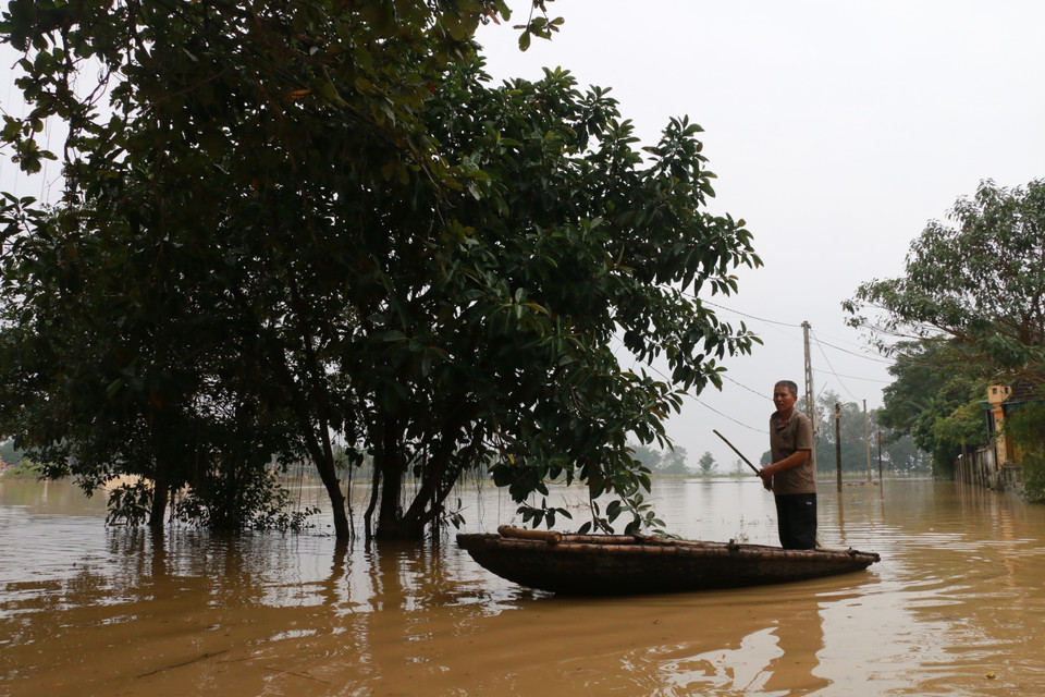 Nước dâng cao khắp mọi nẻo đường, người dân phải di chuyển bằng thuyền. (Ảnh: Bích Huệ/TTXVN)