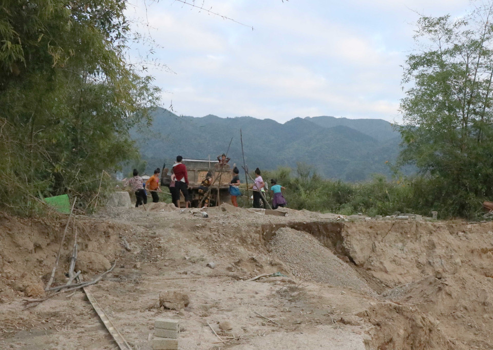 Người dân địa phương xúc cát lên xe tải, vận xuất khỏi địa bàn đi tiêu thụ. (Ảnh: Xuân Tiến/TTXVN)