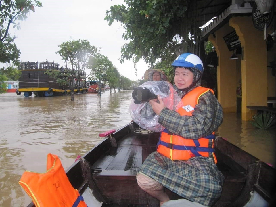 Phóng viên ảnh Trần Lê Lâm (Cơ quan TTXVN khu vực miền Trung-Tây Nguyên) ghi lại những hình ảnh về đợt mưa lũ tại phố cổ Hội An. (Ảnh: TTXVN)