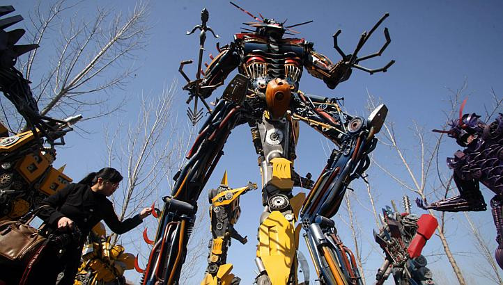 Một người phụ nữ đứng cạnh mô hình robot có kích thước giống như trong phim. (Ảnh: AFP)