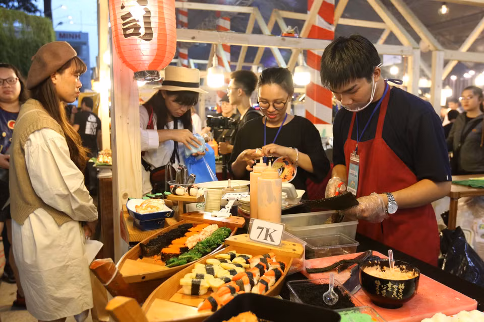 Khách trong nước và quốc tế thưởng thức món cơm cuộn của Nhật Bản tại liên hoan. (Ảnh: Thanh Vũ/TTXVN)