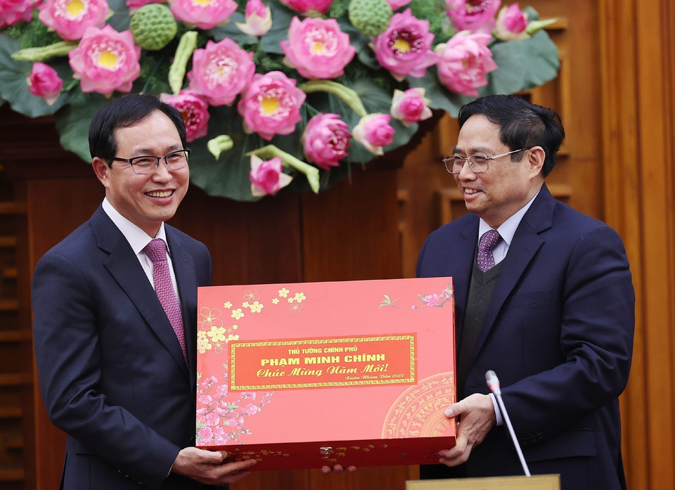 Thủ tướng Phạm Minh Chính tặng quà cho lãnh đạo nhân viên Tổ hợp Samsung Việt Nam. (Ảnh: Dương Giang/TTXVN)