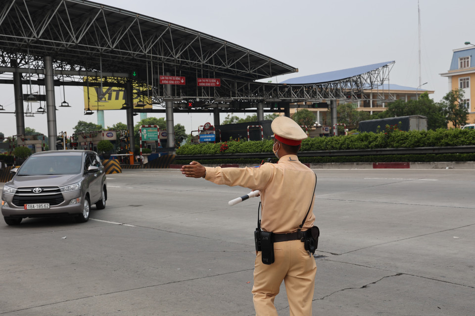 Cảnh sát giao thông Hà Nội hướng dẫn các xe vào chốt kiểm soát dịch khai báo y tế. (Ảnh: TTXVN phát)