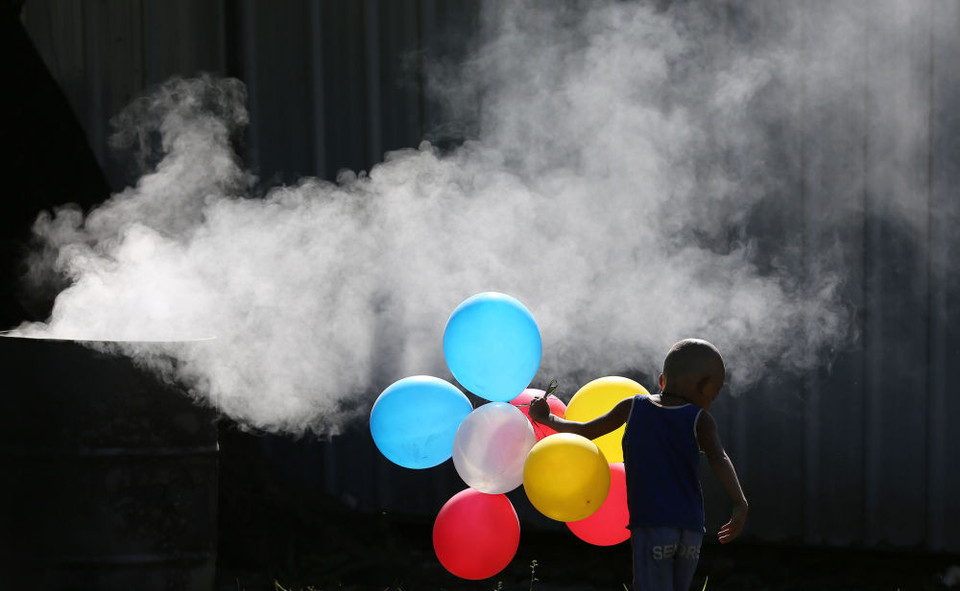 Một cậu bé người Philippines chơi với bóng bay cạnh thùng rác ở Manila. (Ảnh: AP)