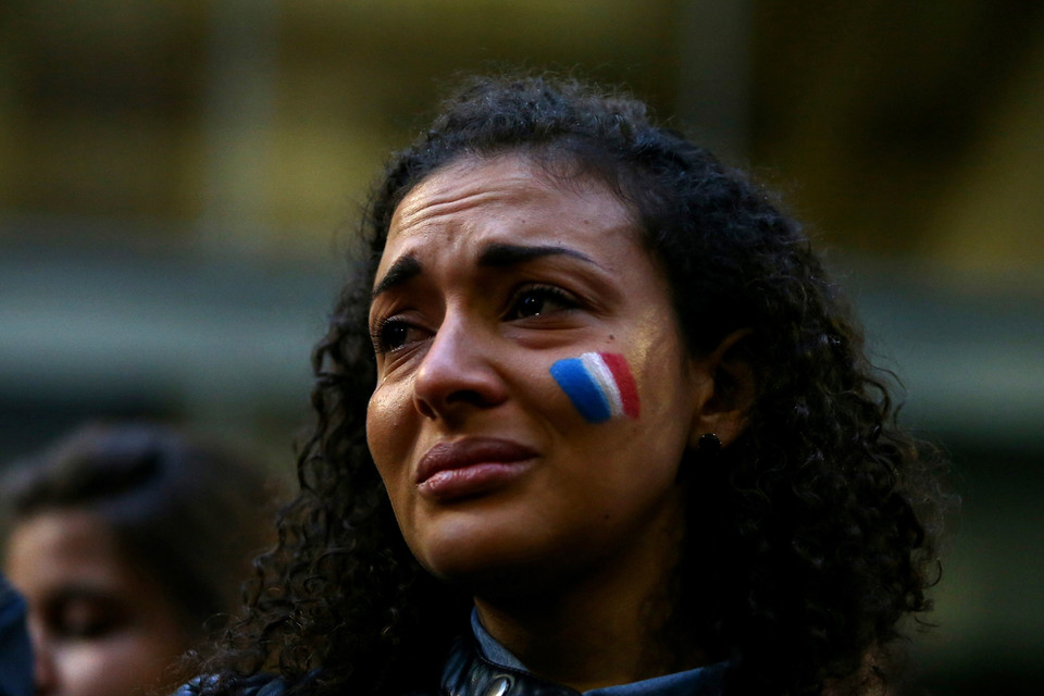 Một phụ nữ vẽ hình quốc kỳ Pháp trên mặt trong buổi lễ cầu nguyện cho các nạn nhân trong 6 vụ tấn công khủng bố Paris tổ chức tại cung điện Martin, Sydney, Australia. (Ảnh: Getty)