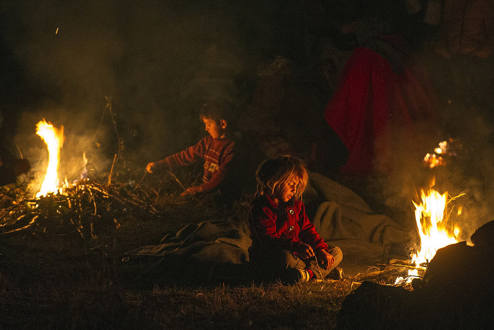 Những đứa trẻ chơi quanh đống lửa tại biên giới Hy Lạp-Macedonia. (Ảnh: AFP)